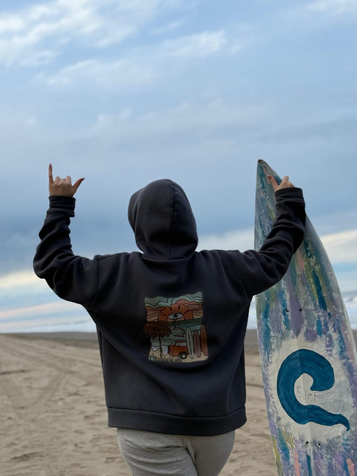 Persona con hoodie LYON frente al mar